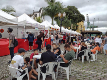 pessoas comendo em praça de alimentação do evento #paratodosverem